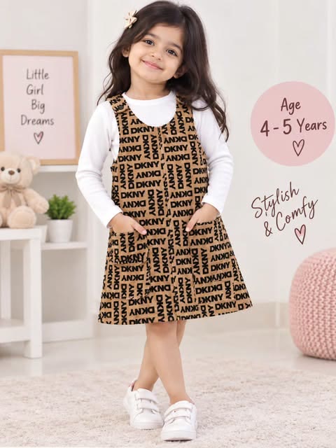 Young girl wearing a printed pinafore dress with a white full-sleeve top